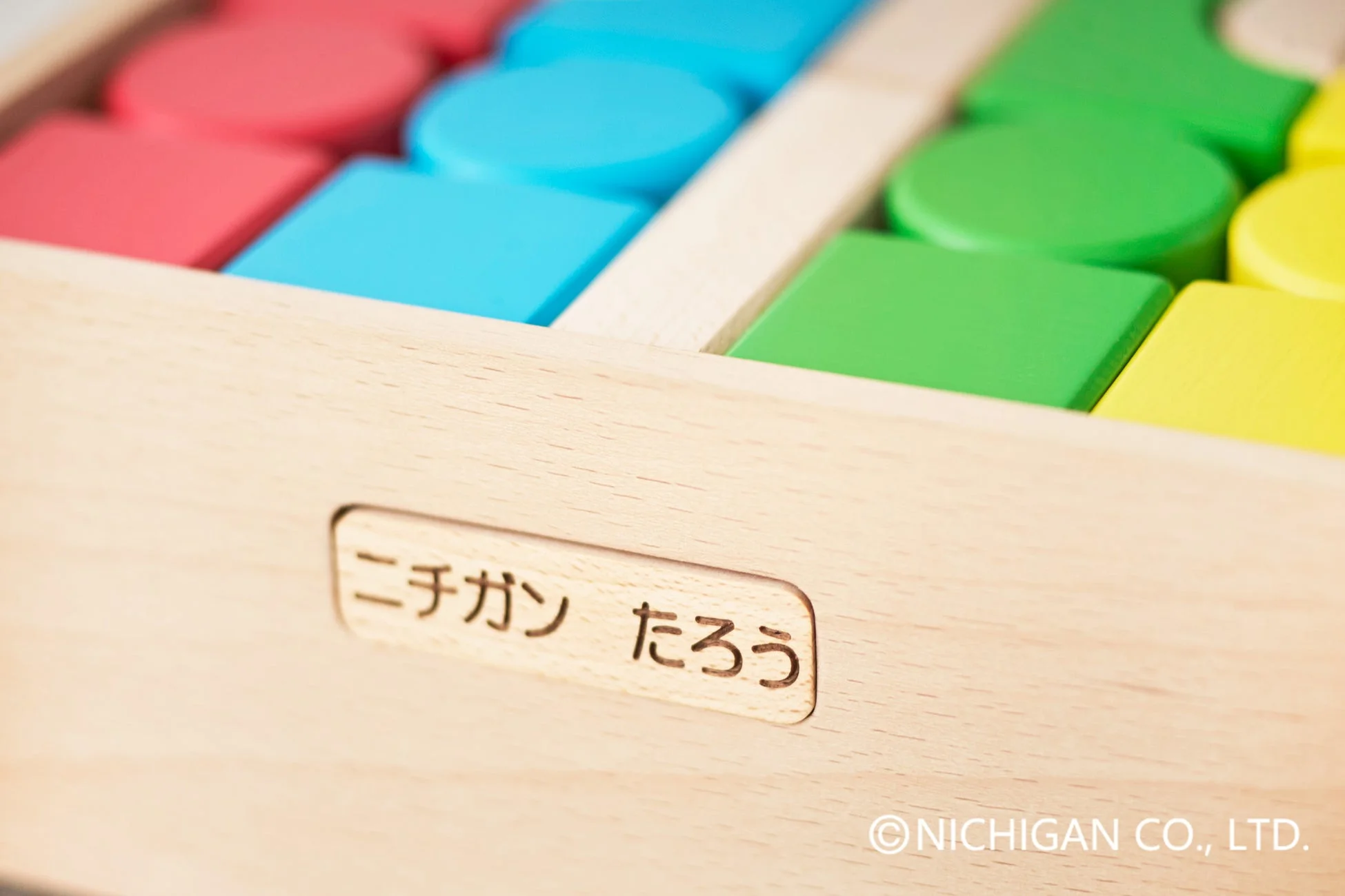 名入れされた知育玩具であることが分かる木製のおもちゃ箱