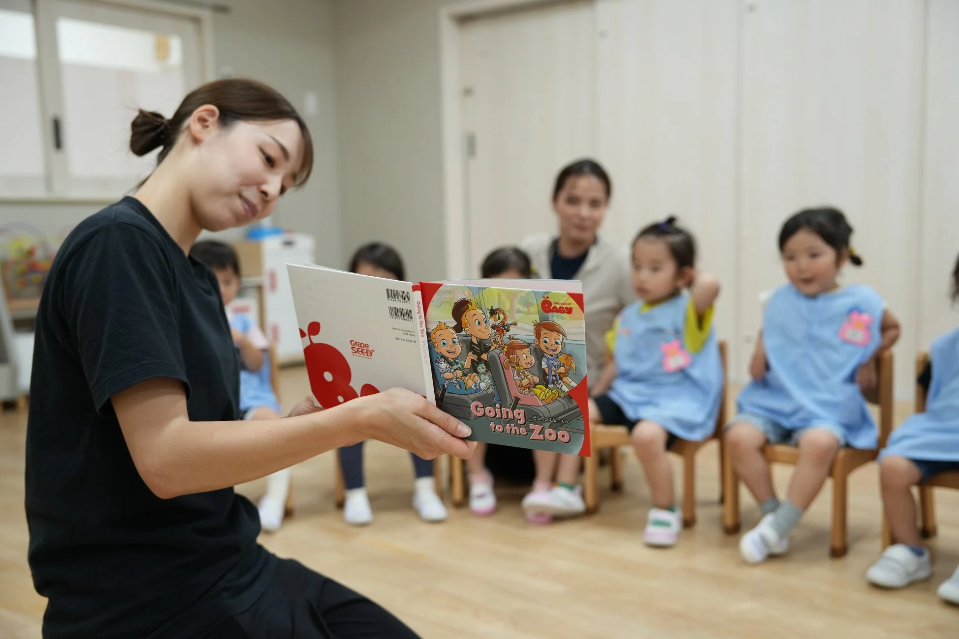 保育士が園児に絵本を読み聞かせている様子