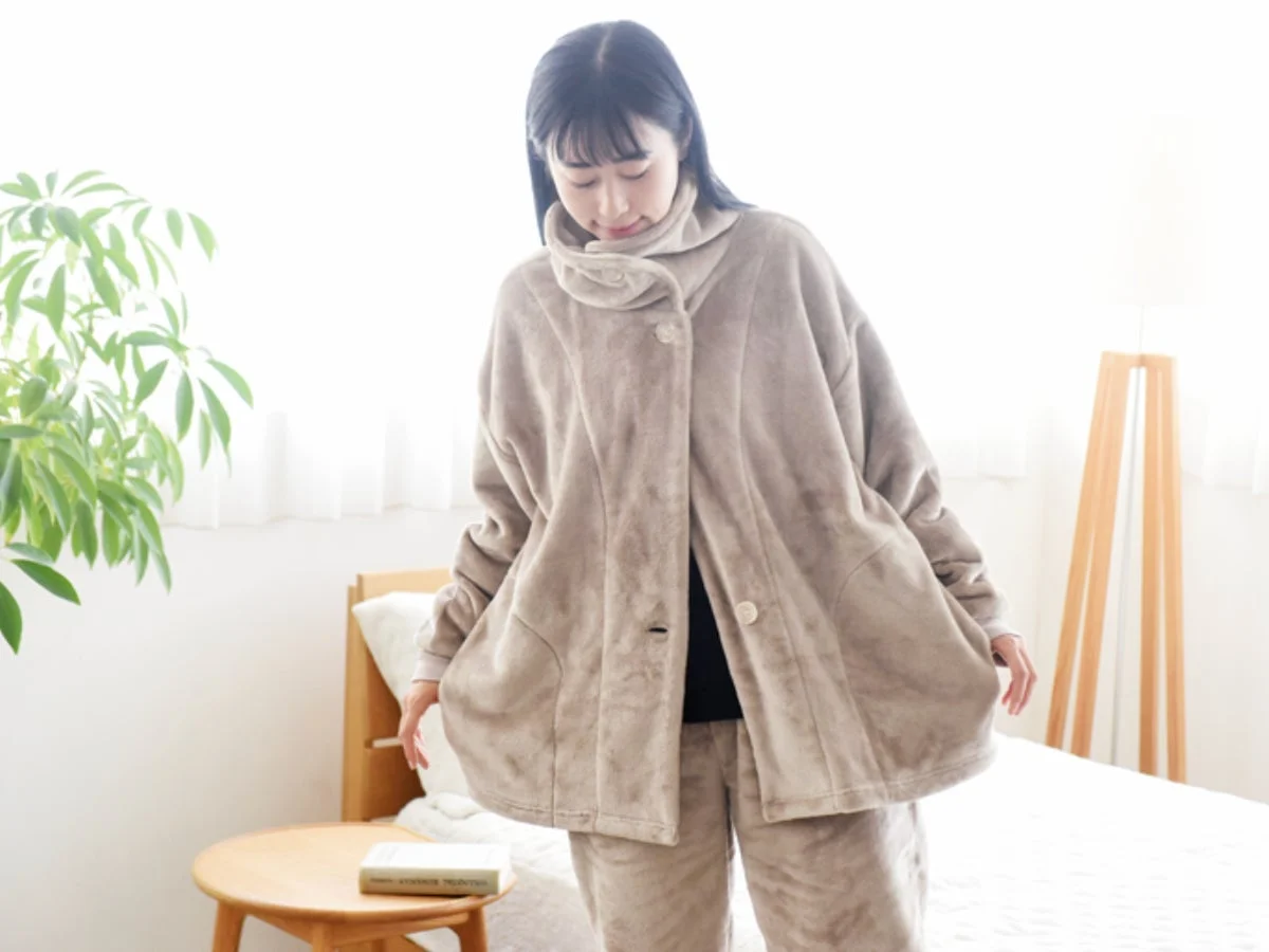 ベージュのハイネック着る毛布でくつろぐ女性