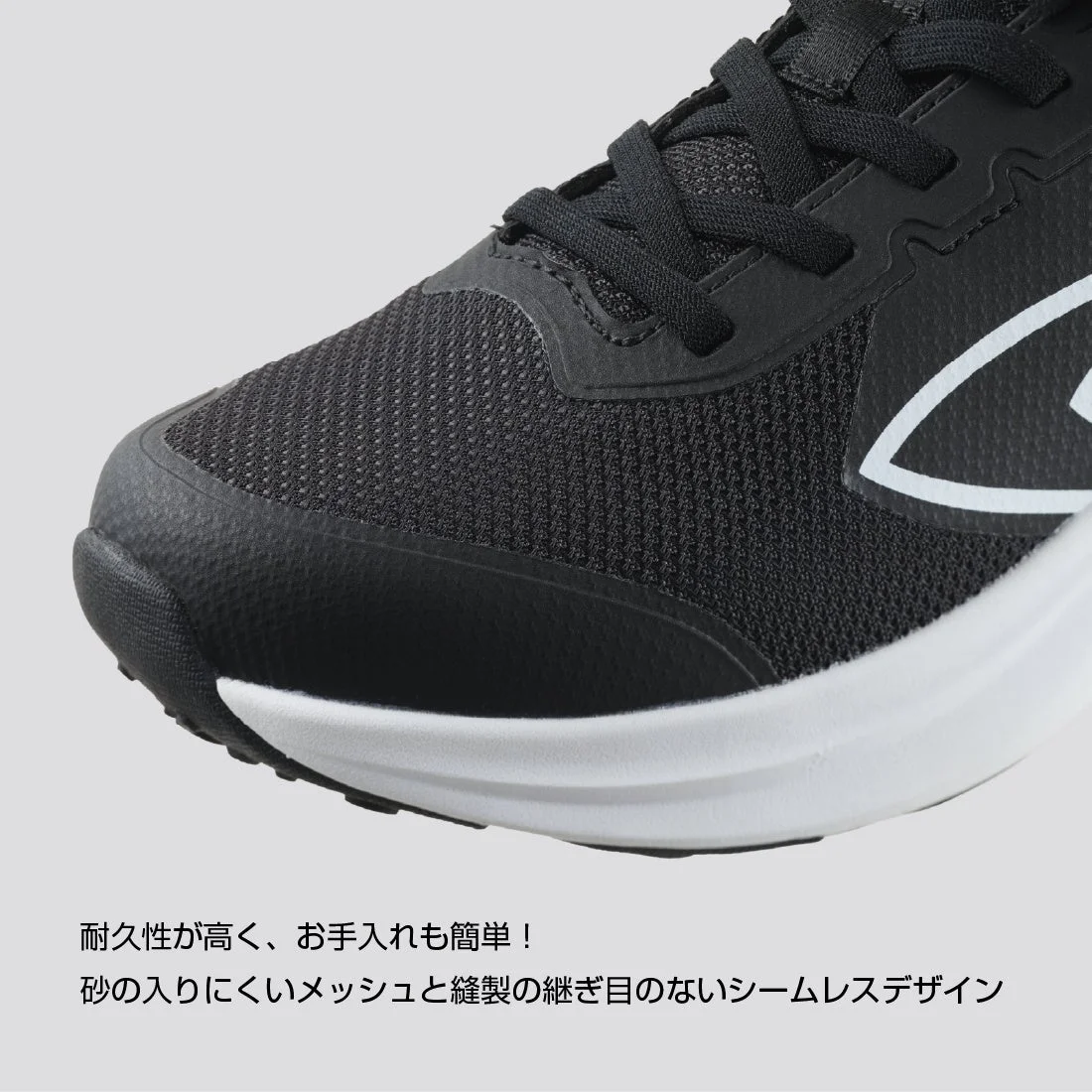 耐久性が高く、お手入れも簡単な黒いスポーツシューズのつま先部分をクローズアップした画像です。砂が入りにくいメッシュ素材と縫い目のないシームレスデザインが特徴です。