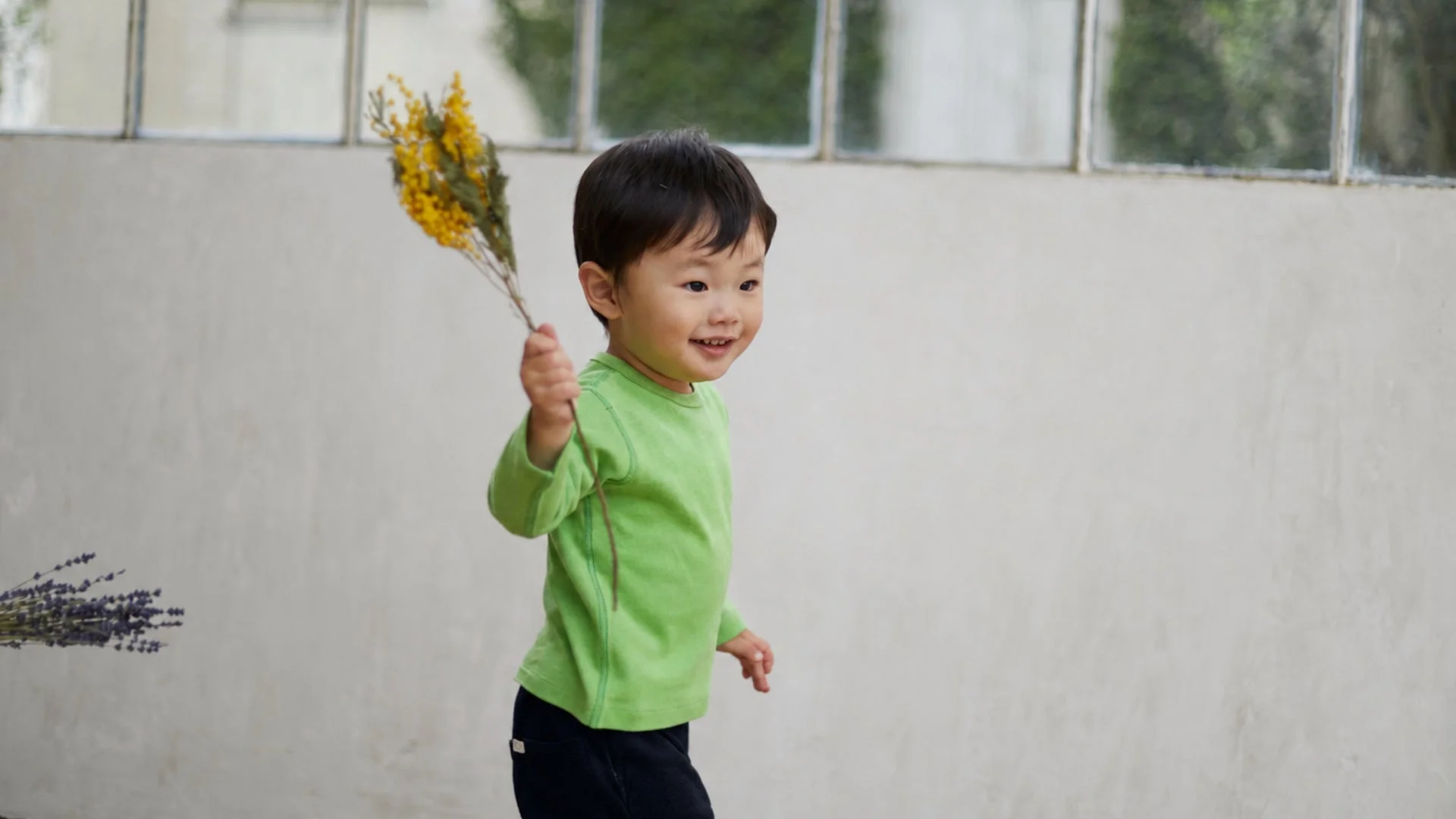 笑顔の男の子がミモザの花束を持ち