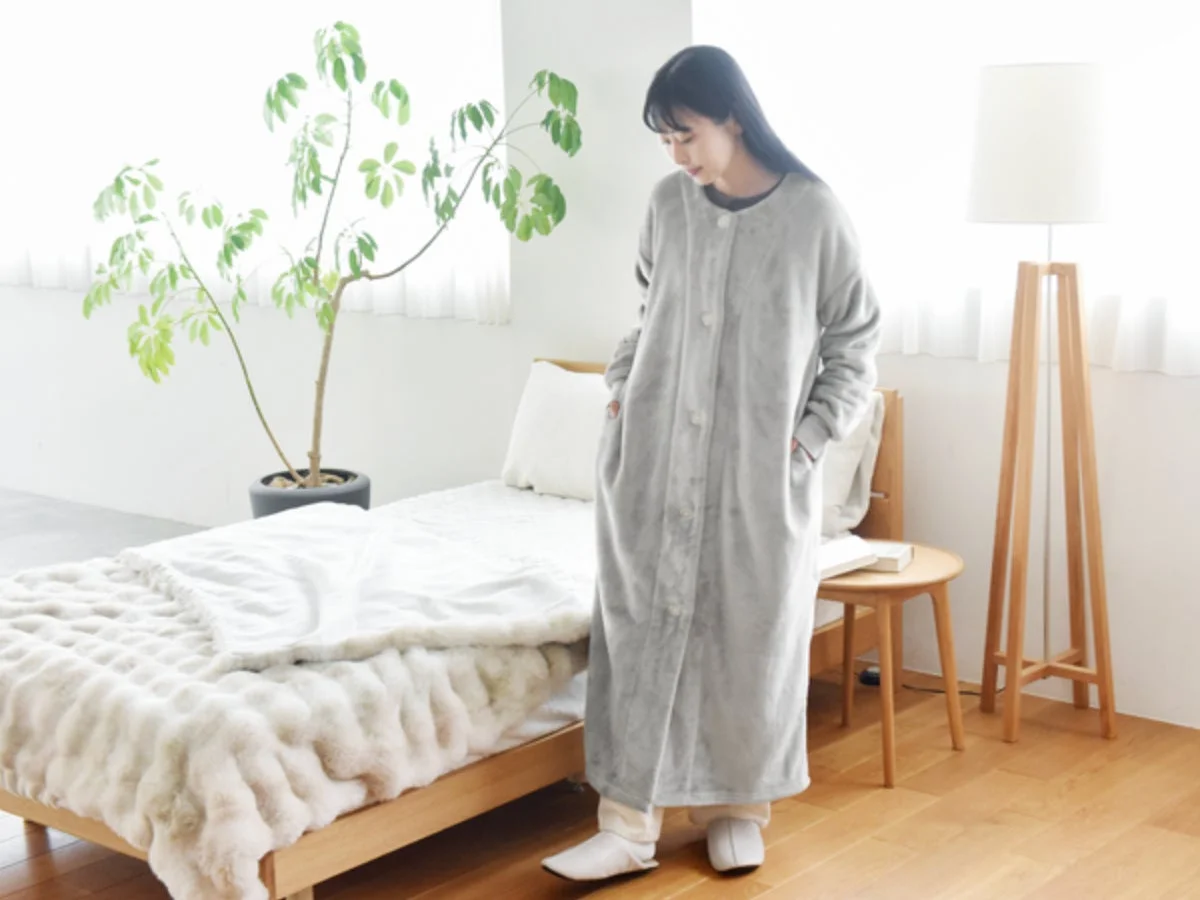 グレーのロング丈着る毛布を着用する女性