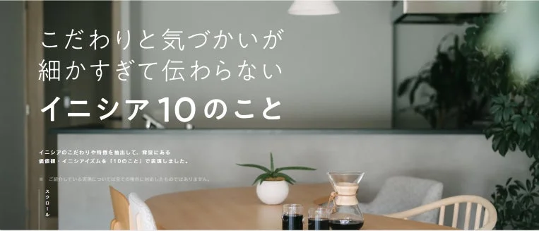 モダンでミニマムなリビングまたはダイニングルームの画像です。テーブルにはコーヒー器具と観葉植物が置かれ、心地よい空間が演出されています。画像には「こだわりと気づかいが細かすぎて伝わらない イニシア10のこと」というキャッチコピーと、イニシアの価値観を表現した説明文が記載されています。