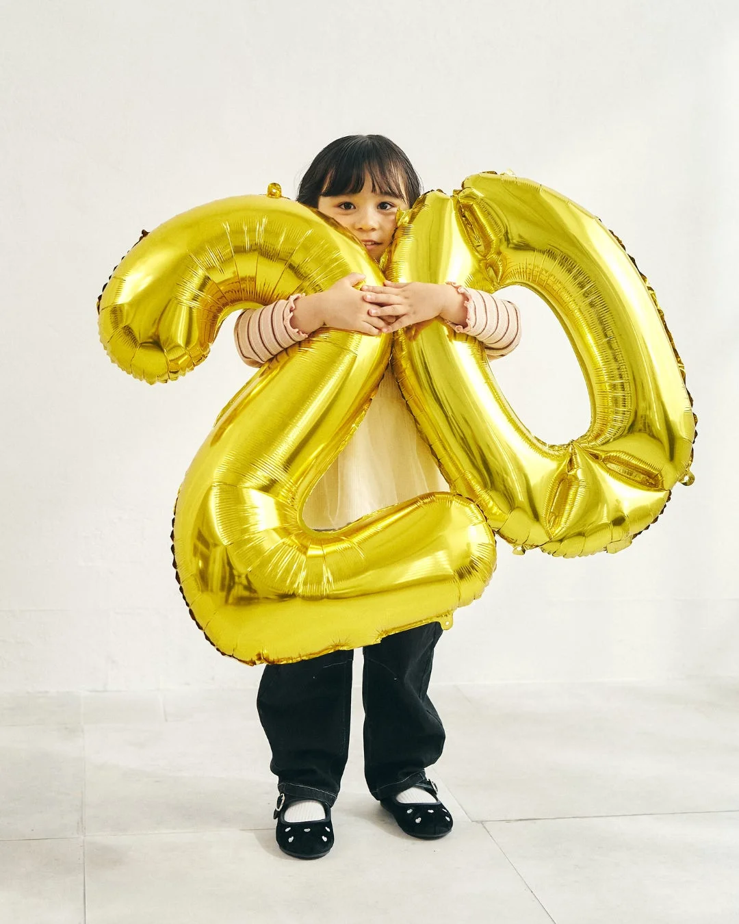 金色の「20」バルーンを持つ女の子