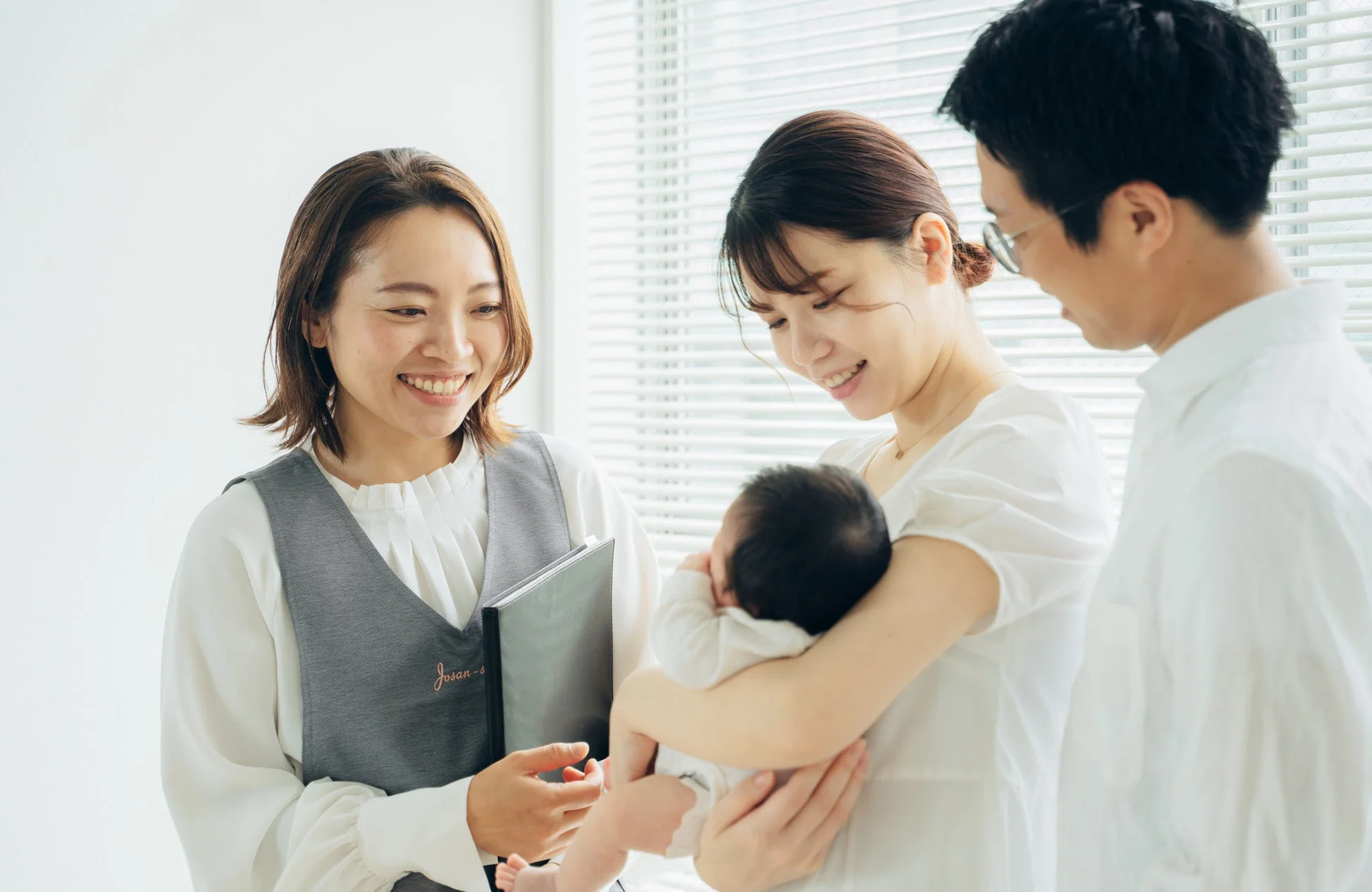 助産師が夫婦と赤ちゃんに話す様子
