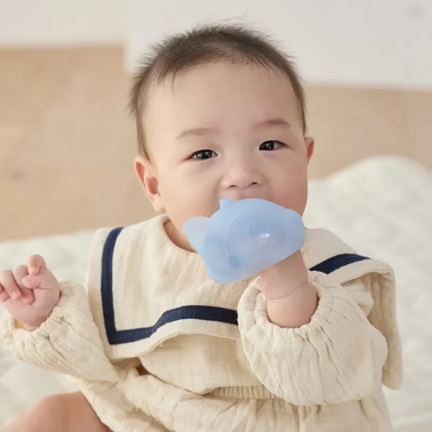 歯がためを口にする赤ちゃん