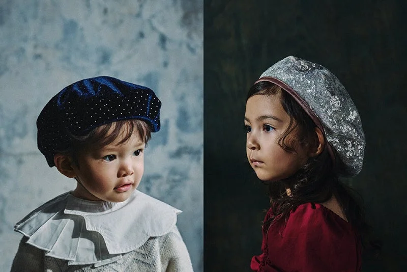 左右に分かれた背景を背に、クラシックな衣装を身につけた二人の子供が写っています。