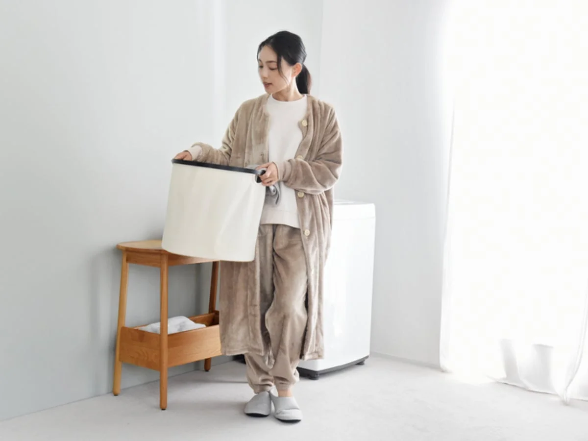 洗濯かごを持つ女性とはく毛布ルームパンツ