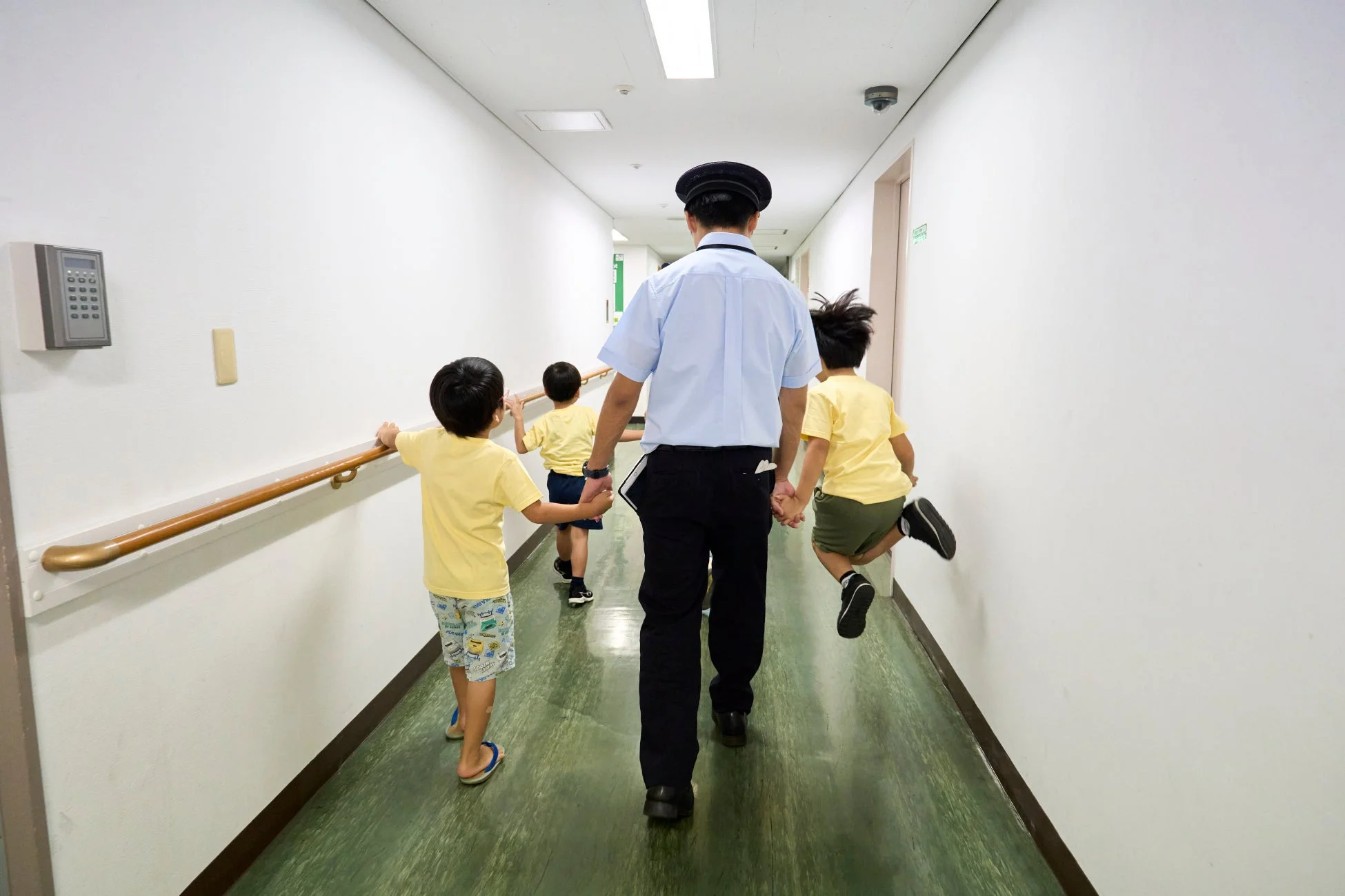 廊下を歩く子どもたちと引率の大人
