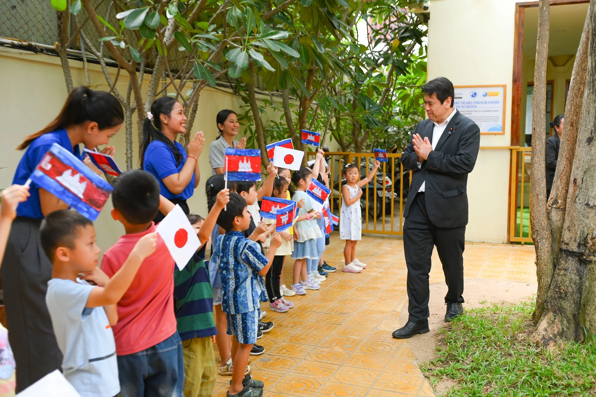 日本とカンボジアの国旗を振って歓迎する子どもたち