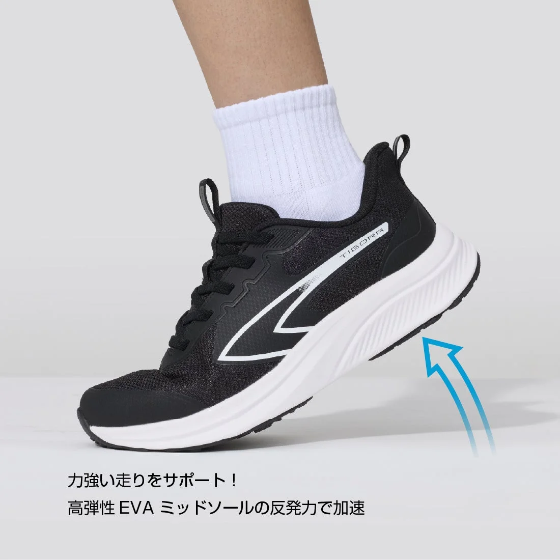 黒いランニングシューズを履いた足元のクローズアップ画像です。高弾性EVAミッドソールの反発力で力強い走りをサポートし、加速を促すことを表現しています。
